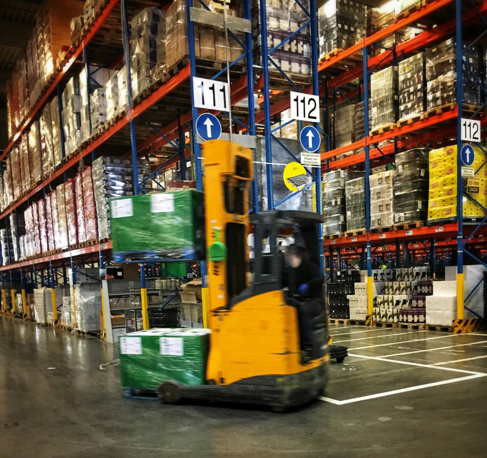 Forklift moving pallets through a distribution warehouse